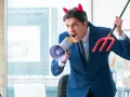 En arg man med djävulshorn och treudd skriker i en megafon, som en narcissistisk chef som kräver uppmärksamhet.