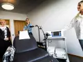 Kvinnor vid utrustning för magnetbehandling depression. En stol och medicinsk apparatur står redo.