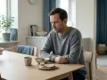 Man vid frukostbordet, nedstämd. Hans depression kan ha lett till viktnedgång, trots en till synes hälsosam måltid.