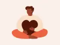 En person sitter i meditationsställning och håller ett hjärta. Detta illustrerar vad betyder mindfulness – att vara närvarande och omfamna sina känslor.