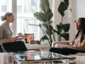 En kvinna och en man sitter mitt emot varandra i ett rum. Kvinnan håller en surfplatta och talar. Mannen lyssnar. Kanske diskuterar de hur mycket kostar terapi.