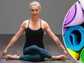 Kvinna i yogaposition, redo för liggande meditation. Rullade yogamattor i bakgrunden.