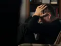 Man med händerna mot huvudet, djupt försjunken i tankar. En påminnelse om att bli mentalt stark genom svåra stunder.