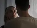 En kvinna med en blick som vittnar om inre styrka möter en mans blick.