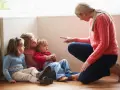 Kvinna pekar på barn som sitter på golvet. En svår samarbetssamtal med narcissist.