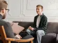 En ung man sitter i samtal med en terapeut. En viktig del av psykoterapi behandling är att skapa en trygg miljö.