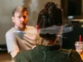 Två personer i samtal, en kvinna med håret uppsatt och en man i bakgrunden. Kanske diskuterar de kbt behandling pris.
