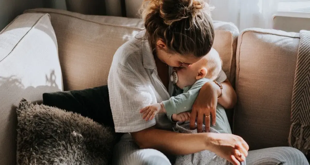 Mamma tröstar sitt barn på en soffa. En lugn stund som hjälper till att hantera oro.