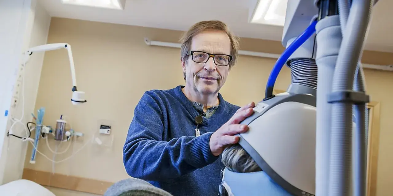 Man med glasögon vid medicinsk utrustning, en del av en ny svår depression behandling.