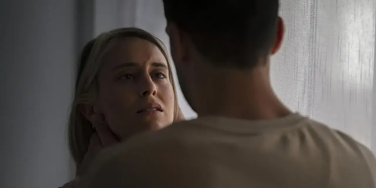 En kvinna med en blick som vittnar om inre styrka möter en mans blick.