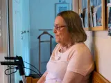 Äldre kvinna med glasögon sitter och funderar, kanske över ett hypokondri test. En rollator står bredvid.
