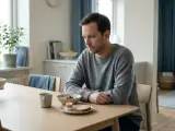 Man vid frukostbordet, nedstämd. Hans depression kan ha lett till viktnedgång, trots en till synes hälsosam måltid.