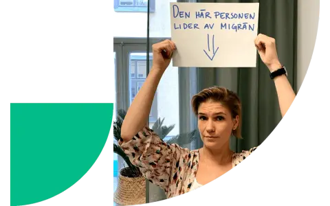 Kvinna håller upp skylt: "Den här personen lider av migrän". Stress kan orsaka domningar i ansiktet.