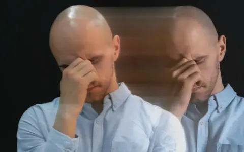 Dubbelbild av en man med slutna ögon som gnuggar sig i pannan, en bild av manodepressiv symtom.