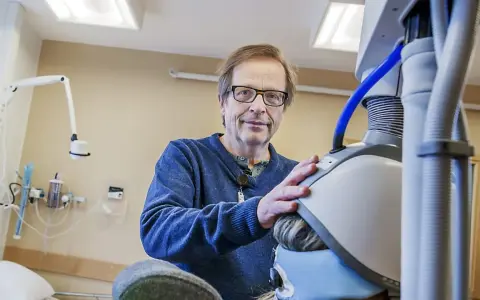 Man med glasögon vid medicinsk utrustning, en del av en ny svår depression behandling.