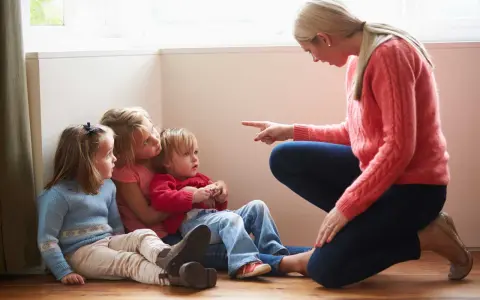 Kvinna pekar på barn som sitter på golvet. En svår samarbetssamtal med narcissist.