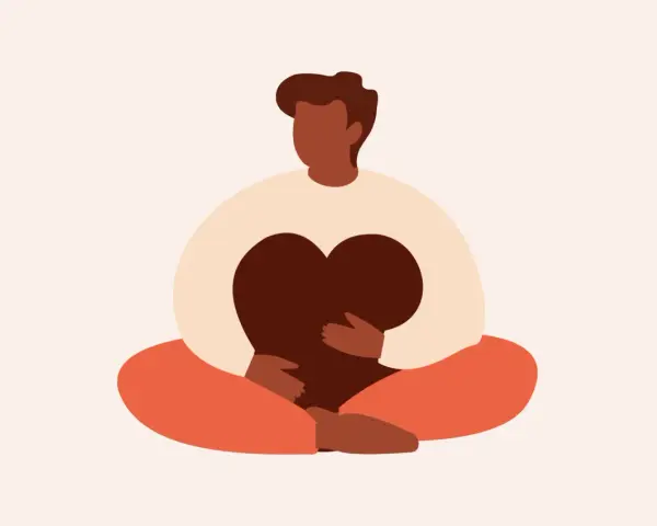 En person sitter i meditationsställning och håller ett hjärta. Detta illustrerar vad betyder mindfulness – att vara närvarande och omfamna sina känslor.