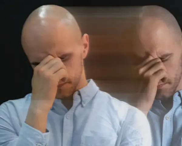 Dubbelbild av en man med slutna ögon som gnuggar sig i pannan, en bild av manodepressiv symtom.