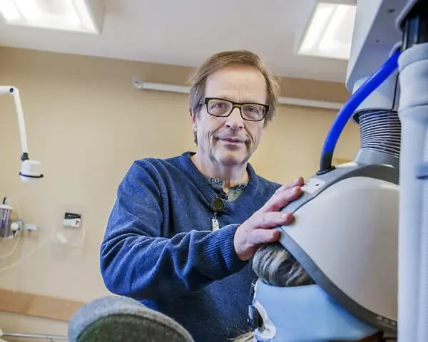 Man med glasögon vid medicinsk utrustning, en del av en ny svår depression behandling.