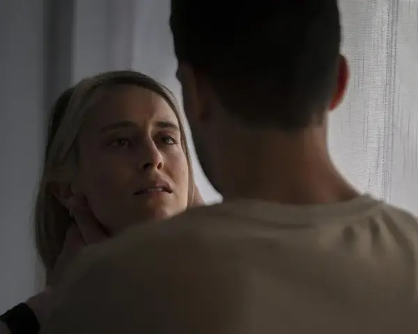 En kvinna med en blick som vittnar om inre styrka möter en mans blick.