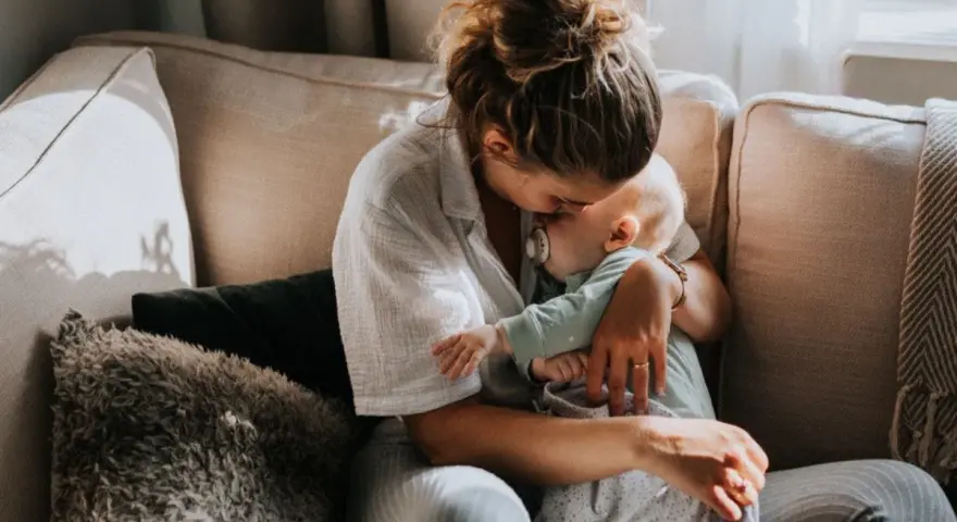 Mamma tröstar sitt barn på en soffa. En lugn stund som hjälper till att hantera oro.
